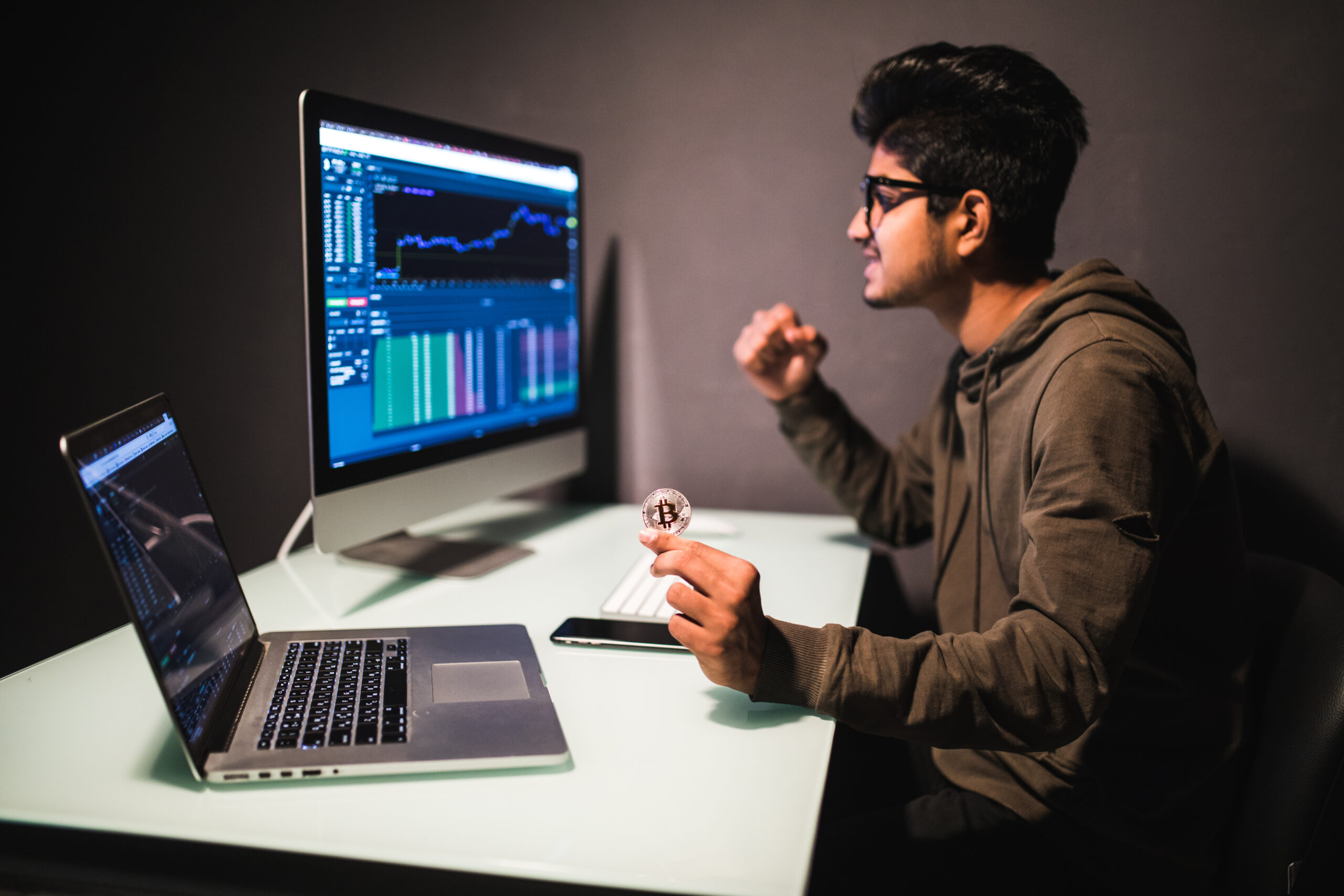 Indian trader with bitcoin checking stock trading data analysis concept working in office with financial graph on computer monitors